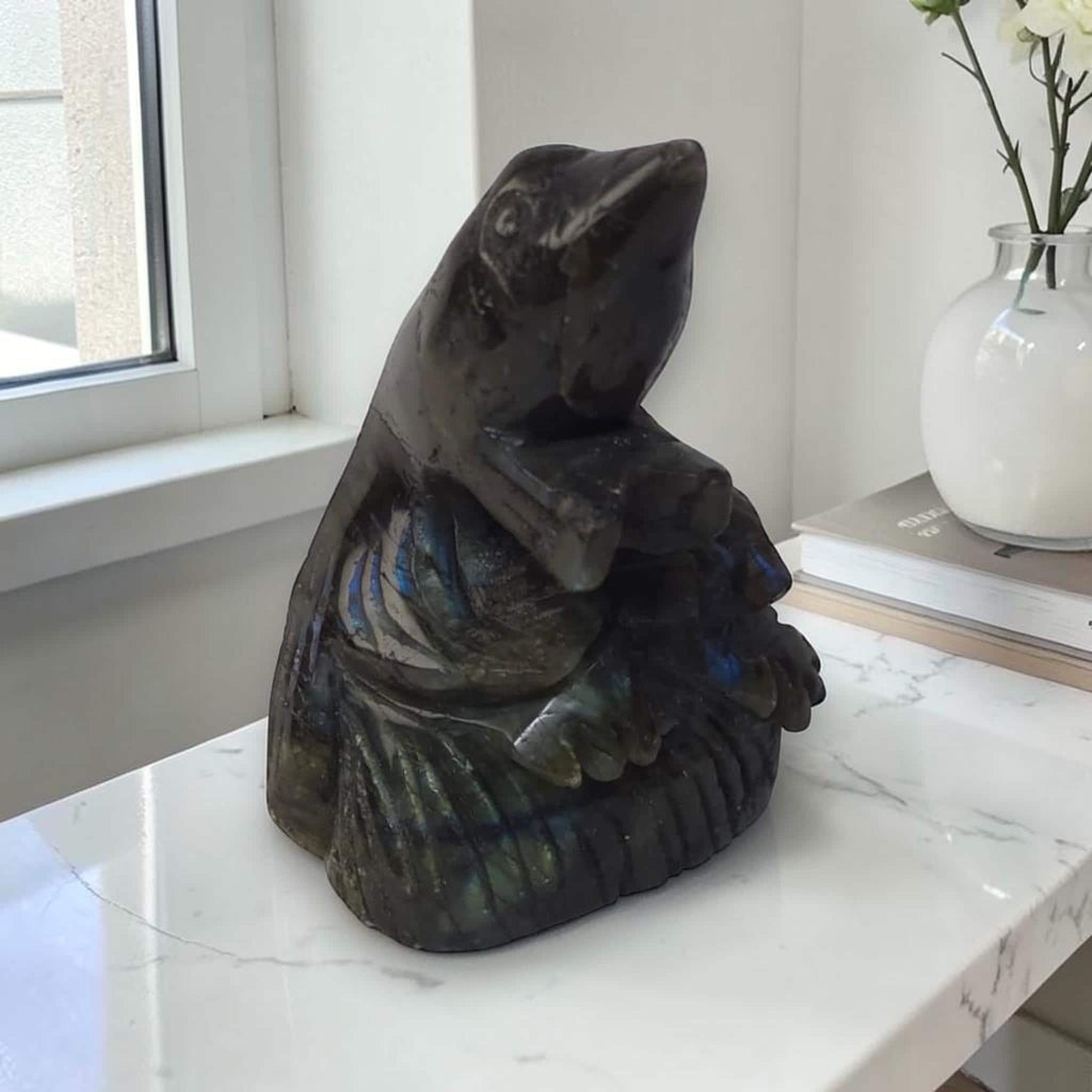 Labradorite bird carving crystal sculpture in dark stone with blue iridescent highlights