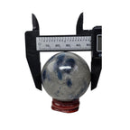 Granite crystal sphere with blue mottling, caliper measurement, on red stand