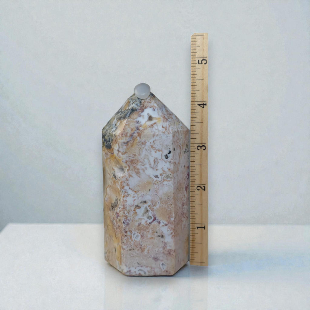 Polished ocean jasper tower with cream and tan swirls, small purple flecks; capped top.