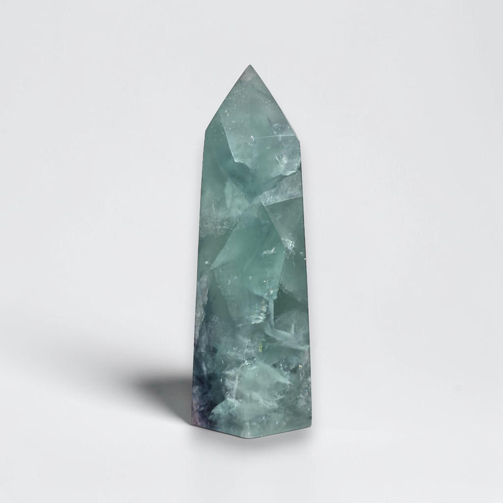 Fluorite crystal tower with pointed top, translucent light green with faceted pattern