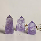 Set of three amethyst quartz point towers, varying purple tones with faceted peaks.
