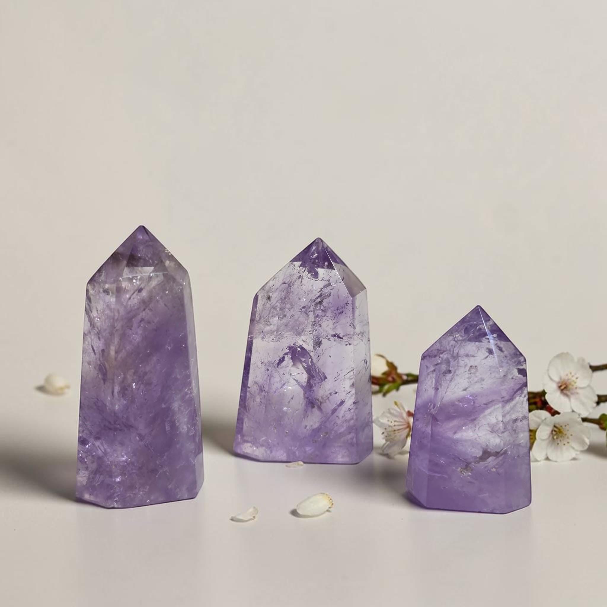 Set of three amethyst quartz point towers, varying purple tones with faceted peaks.