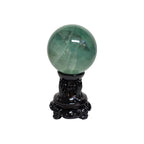 Green fluorite sphere on dark decorative stand with ornate base details