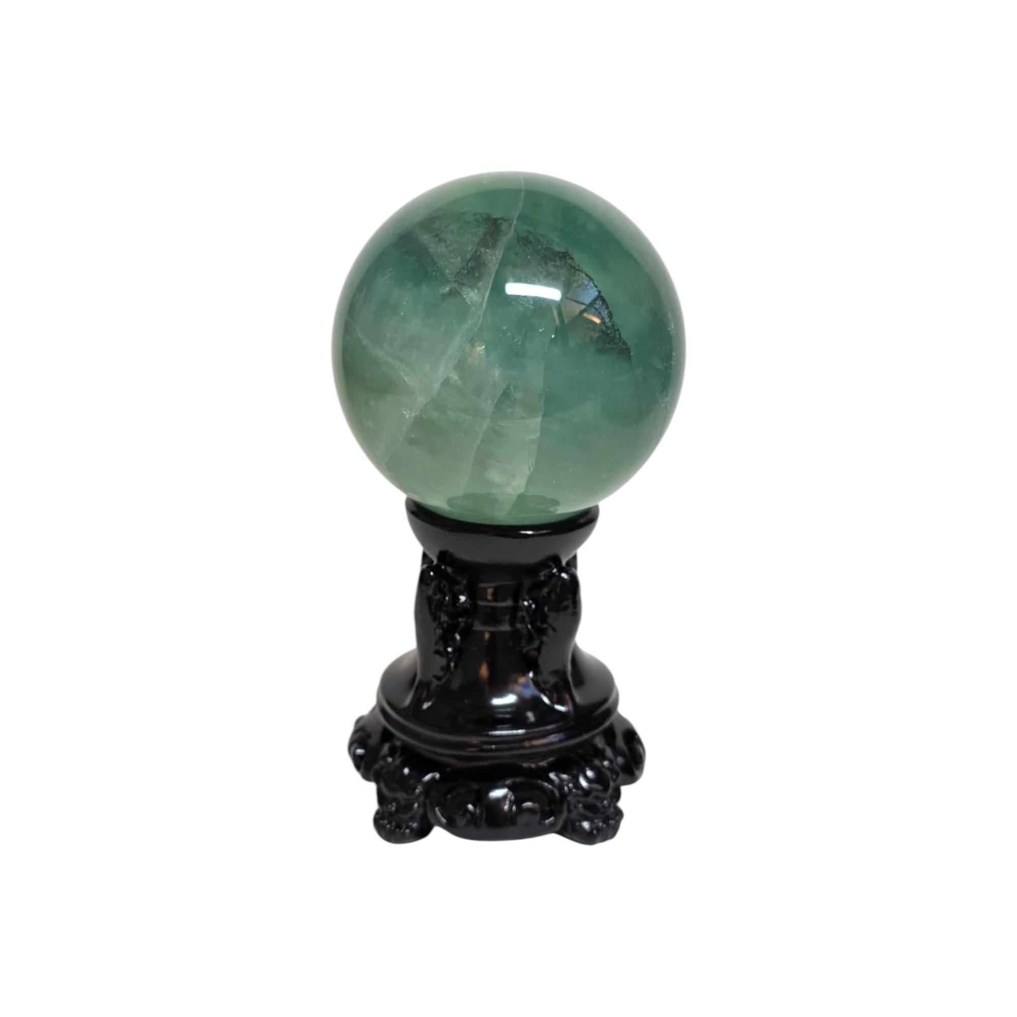 Green fluorite sphere on dark decorative stand with ornate base details