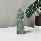 Green moss agate obelisk crystal tower with pointed top and mottled stone texture