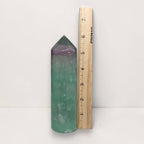 Green fluorite tower next to ruler, purple-tinted top, polished pointed crystal