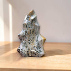 Freeform ocean jasper crystal flame sculpture with black speckles and gold patches