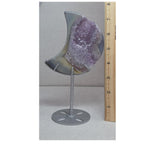 Crescent moon purple druzy agate geode on stand beside measuring tape