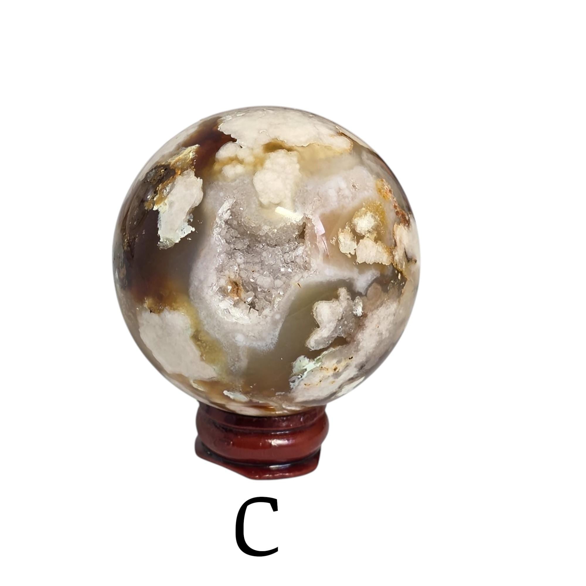 Flower agate drusy sphere on dark red base, gray mineral body with golden crystal highlights
