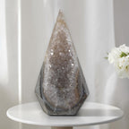 Large quartz geode tower with faceted crystal interior and dark gray stone exterior