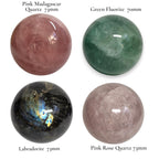 Crystal sphere set featuring pink, green, black, and mauve polished stones