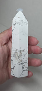 White howlite tower held in hand, gray veining, pointed top
