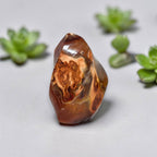 Polished orange agate flame crystal with swirling bands, glossy faceted surface