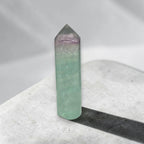 Green fluorite crystal tower with purple-tinted top, polished point and smooth sides