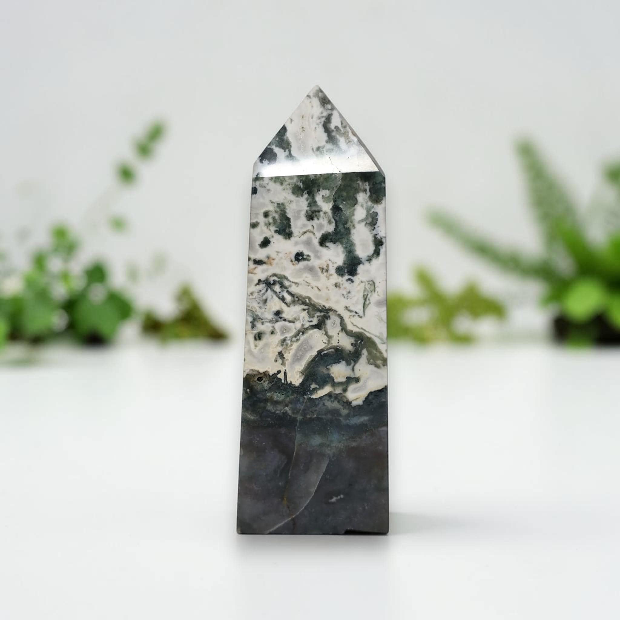 Polished moss agate tower, speckled white stone with dark lower band and subtle green streaks