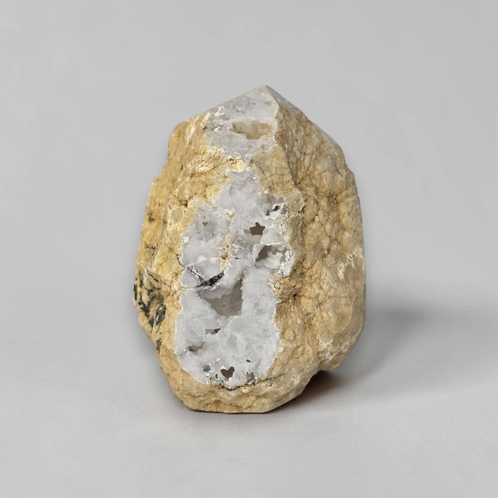 White quartz drusy geode with tan outer matrix and exposed crystal-filled opening.