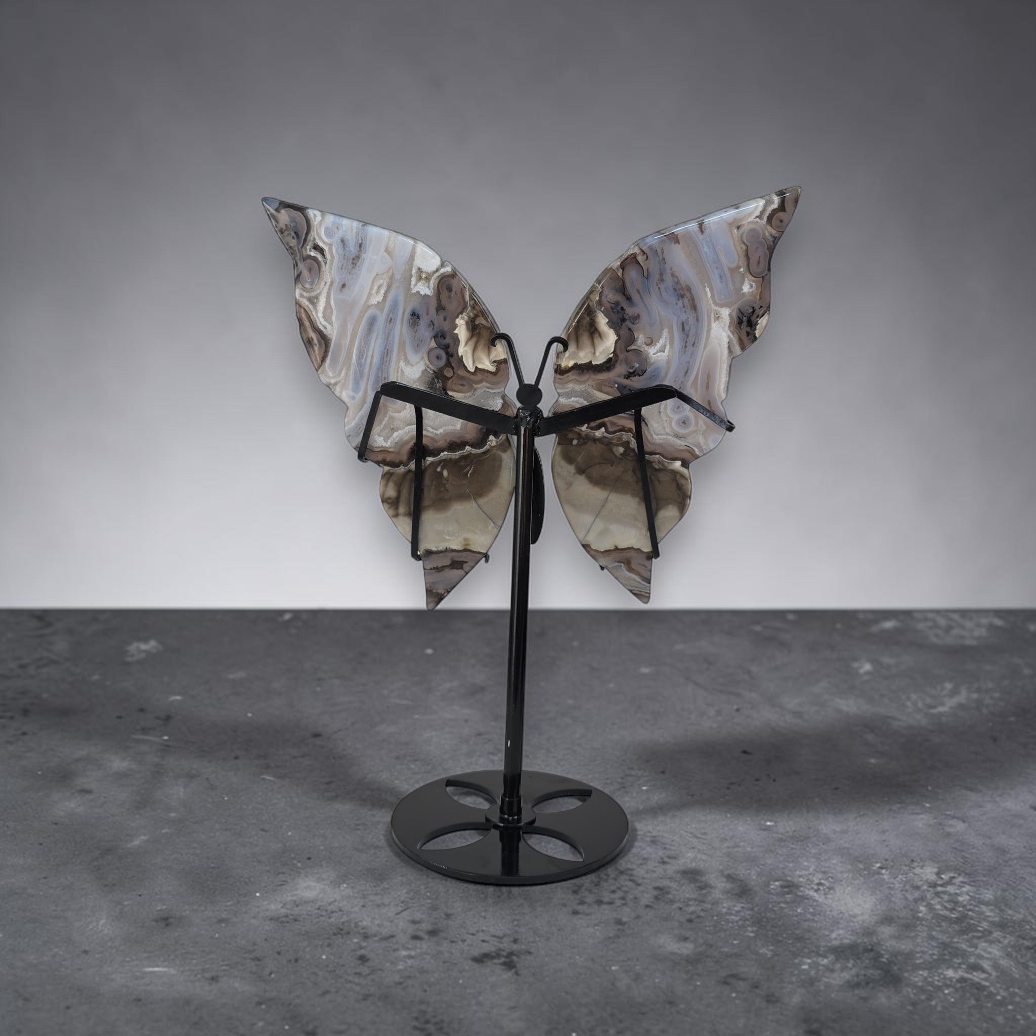 Butterfly-shaped object on a stand against a gray background