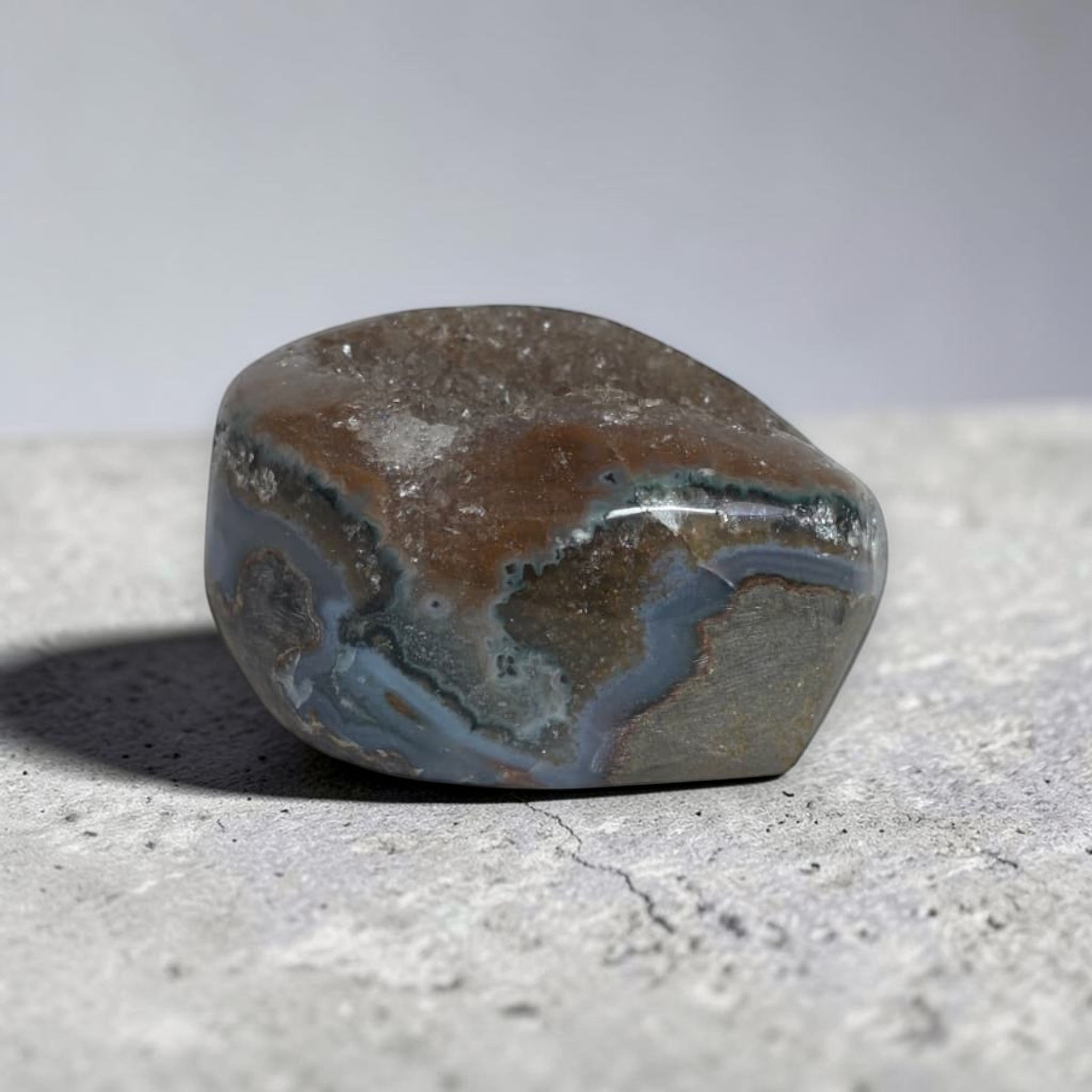 Polished stone with blue and brown patterns on a concrete surface