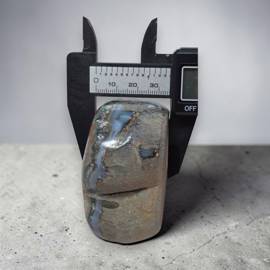 Polished stone with measurement scale on a gray surface