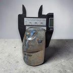 Polished stone with measurement scale on a gray surface