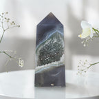 Geometric crystal on a white surface with flowers in the background