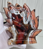 Fox carving with nine tails, brown and white striped pattern held on cloth