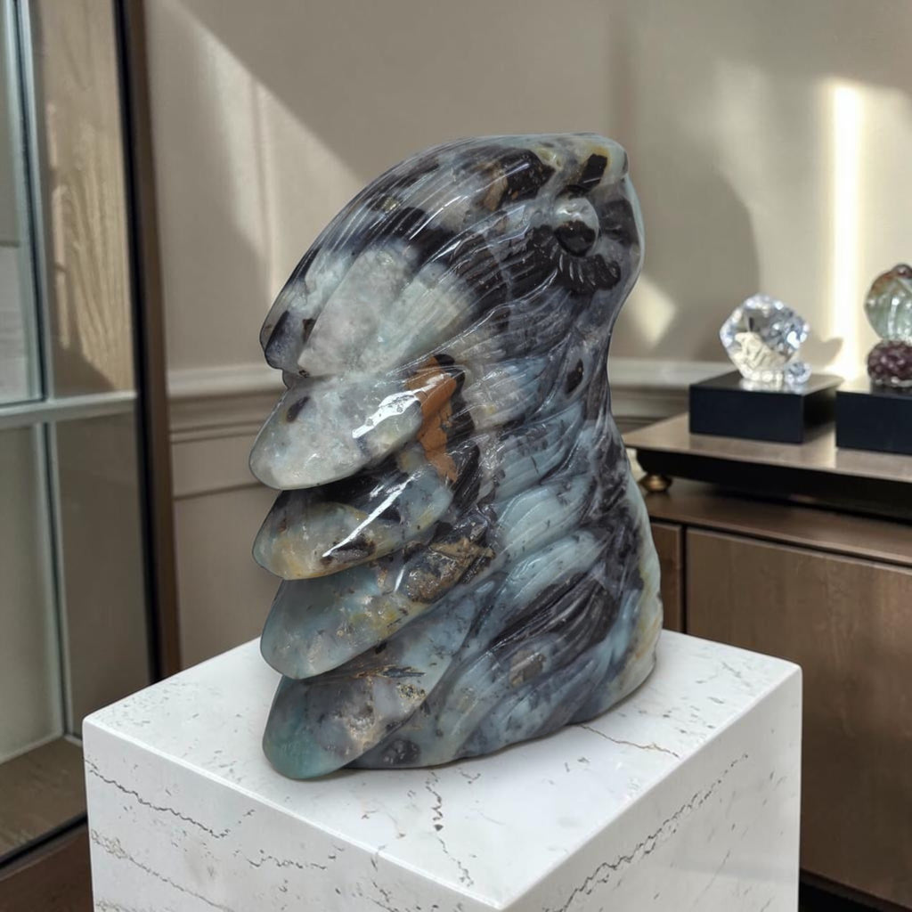 Amazonite eagle head sculpture in blue-gray stone with dark feather pattern and curved beak