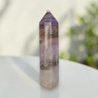 Amethyst-lavender gemstone tower with layered tan bands and faceted top