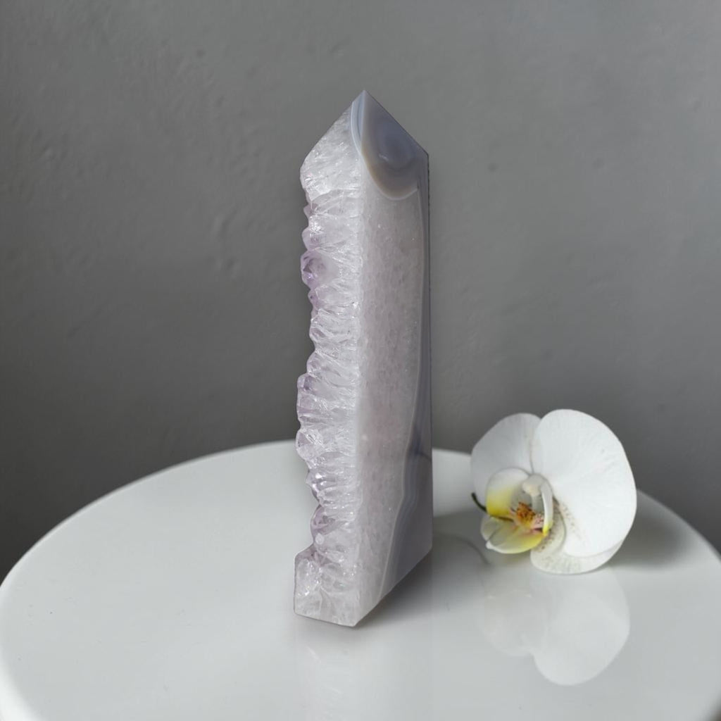 Crystal tower and white orchid on a gray background