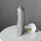 Crystal tower and white orchid on a gray background