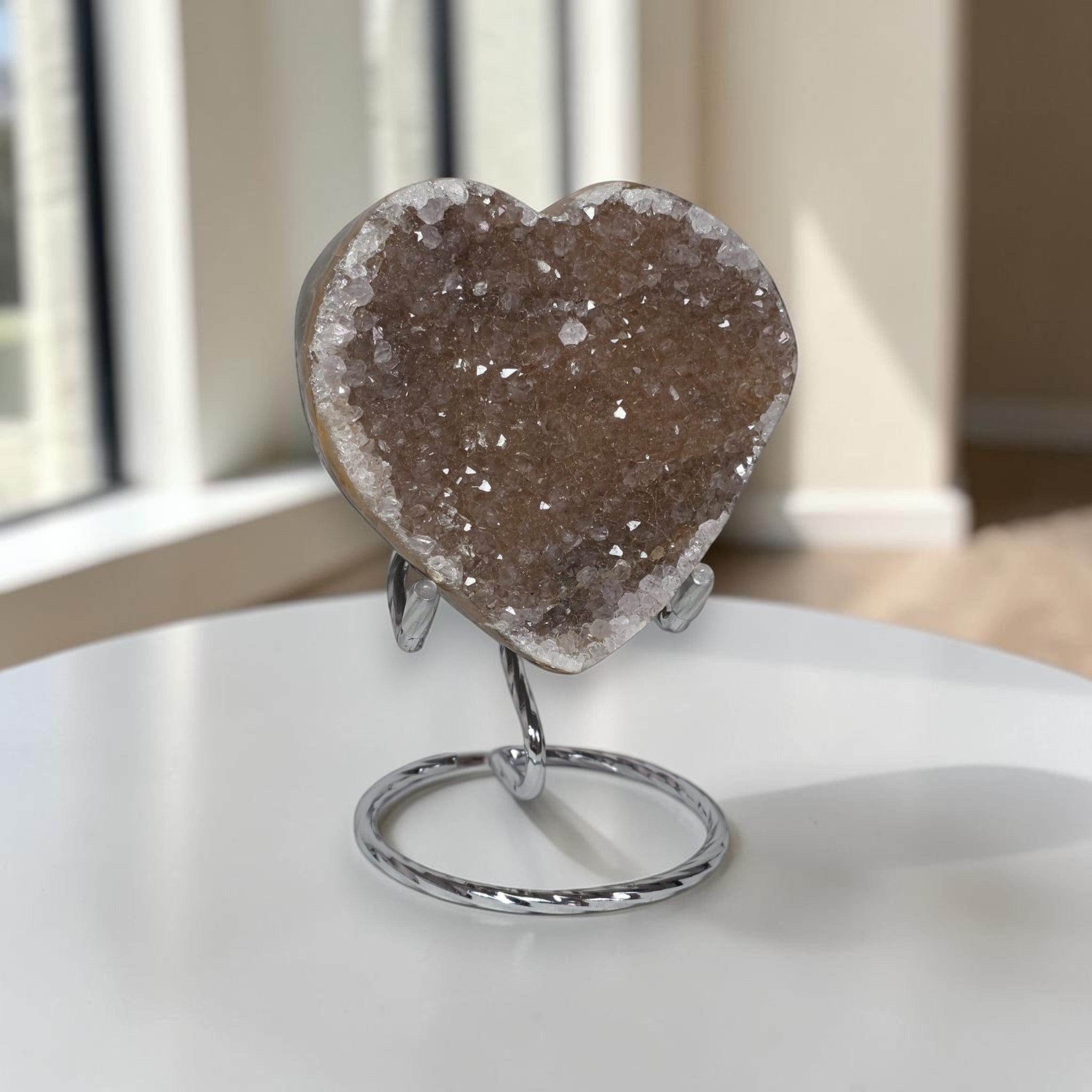 Heart-shaped crystal on a stand in front of a window