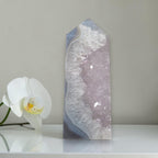 Decorative crystal tower with a white orchid on a neutral background