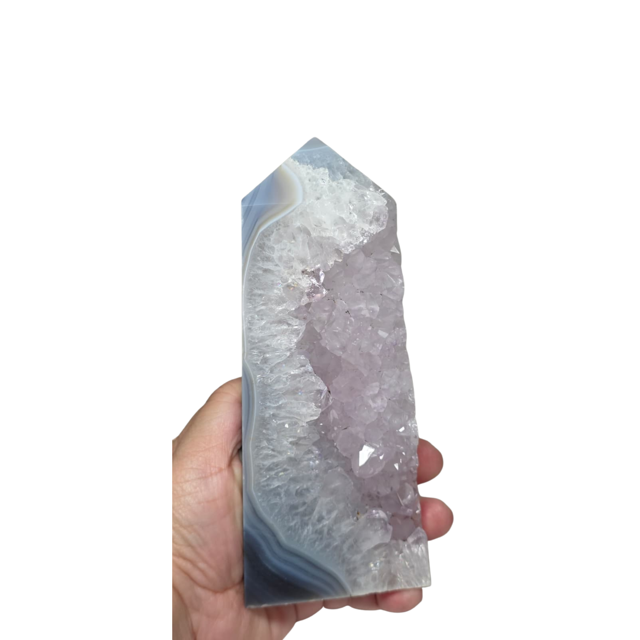 Crystal tower held in a hand against a white background