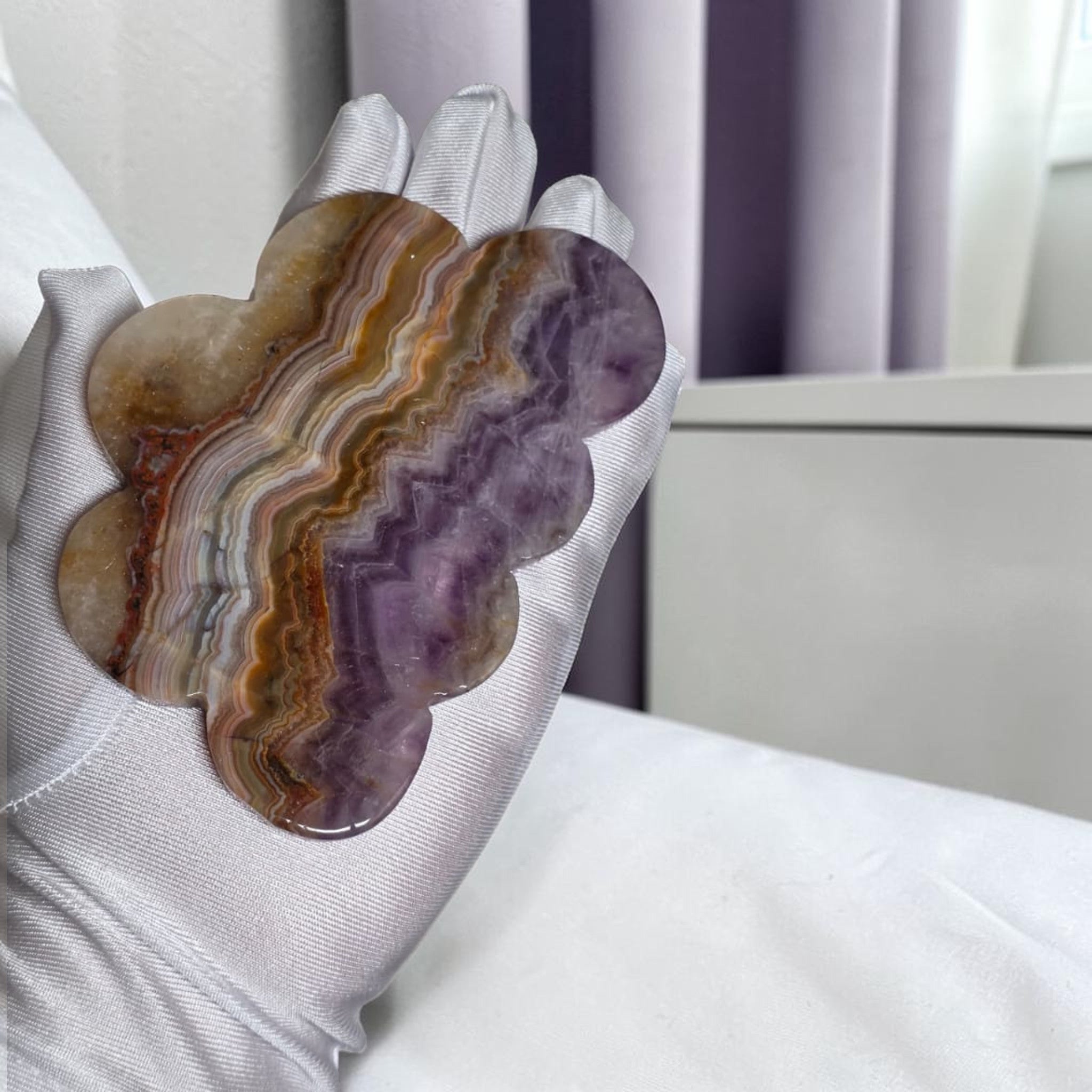 Amethyst lace agate cloud carving closeup showing banded purple and amber layers