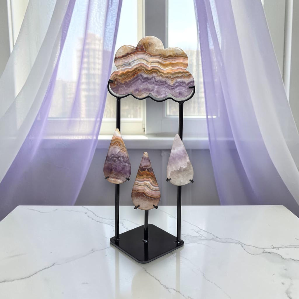 Amethyst lace agate cloud and raindrops sculpture on black metal stand front view