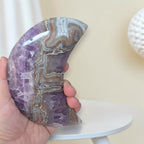 Handheld purple banded agate crescent stone with polished curved surface