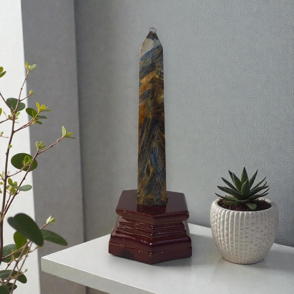 Slim blue kyanite obelisk crystal with dark red wooden stand base