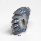Crystal eagle head sculpture, side view in glossy gray-blue stone with feather detail