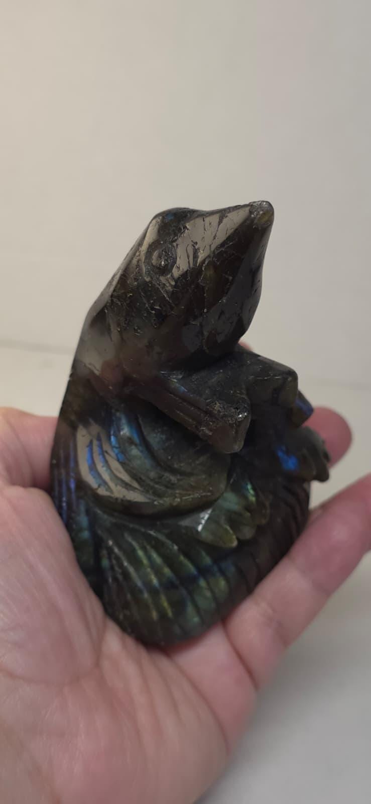Labradorite bird carving, dark stone with blue and green iridescent wings in hand