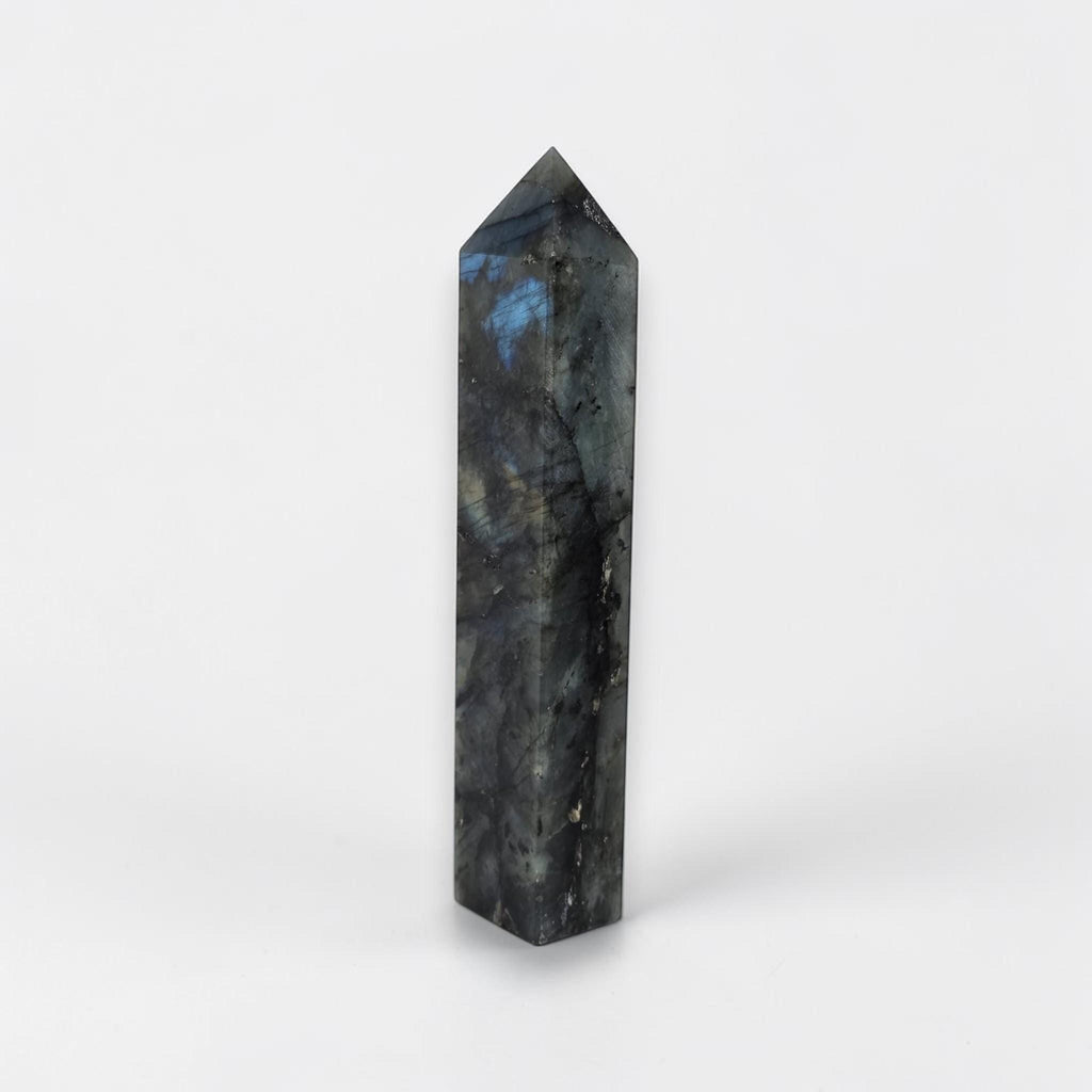 Labradorite crystal tower with faceted pointed top, dark gray and blue glow
