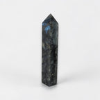 Labradorite crystal tower with faceted pointed top, dark gray and blue glow