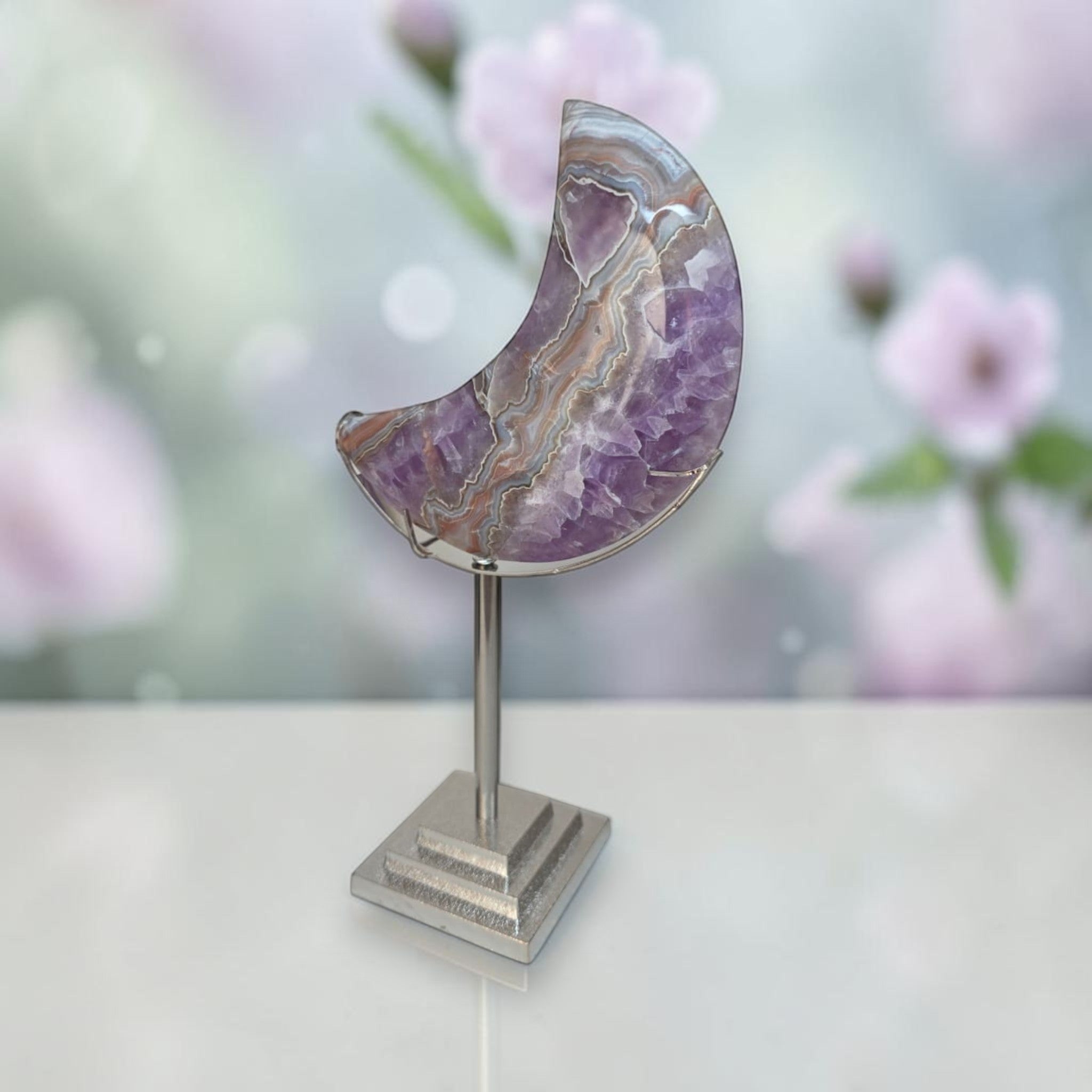 Purple banded agate crescent moon on silver stand, front view