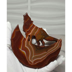 Banded agate wolf moon sculpture held in hand showing size