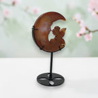 Banded agate moon fairy held in gloved hands, back view showing carved detail