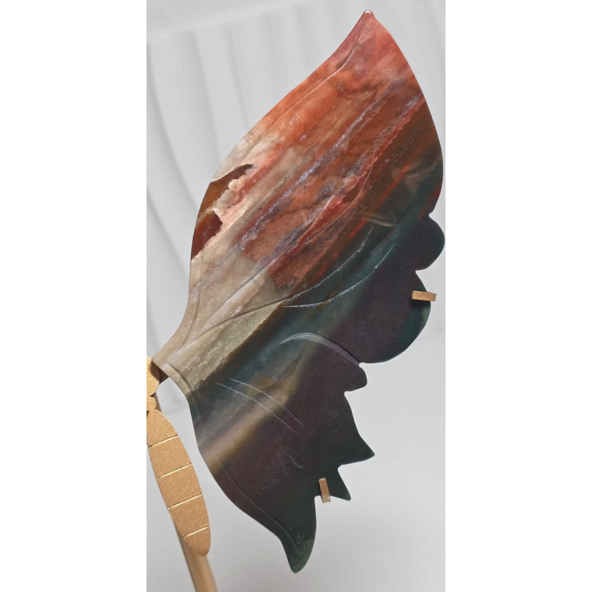 Polished agate butterfly wing held in a hand