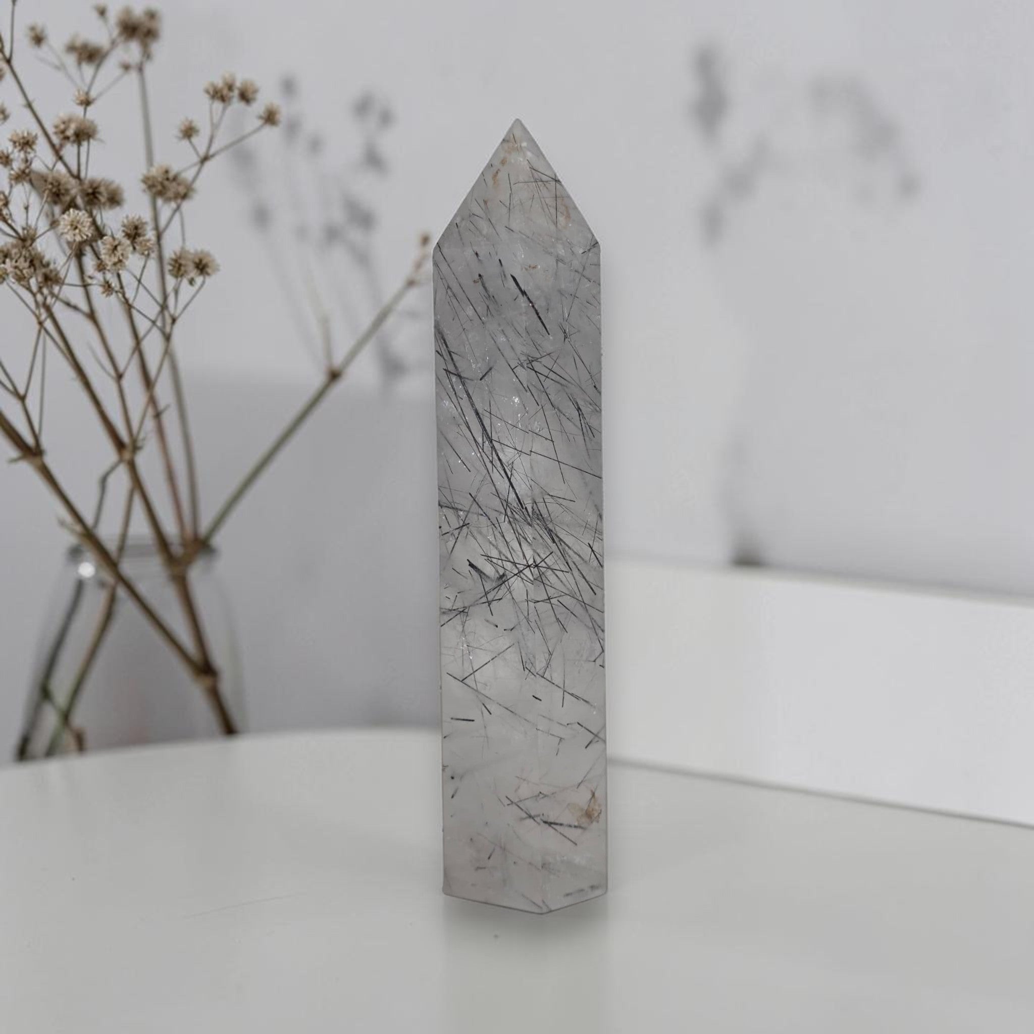 Rutilated quartz obelisk tower with gray crystal body and dark needle inclusions