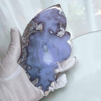 Handheld close-up of blue agate butterfly sculpture with gold-tone details