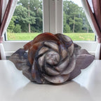Rose-shaped agate carving with sculpted center petals in smoky gray-blue and amber tones