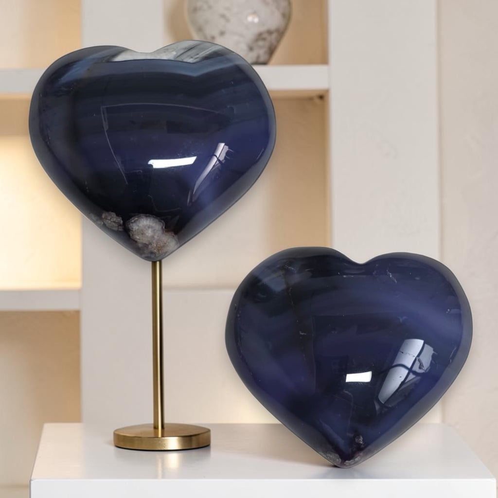 Two blue heart-shaped objects on a white surface with a neutral background