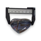 Heart-shaped agate stone with a ruler for scale on a white background